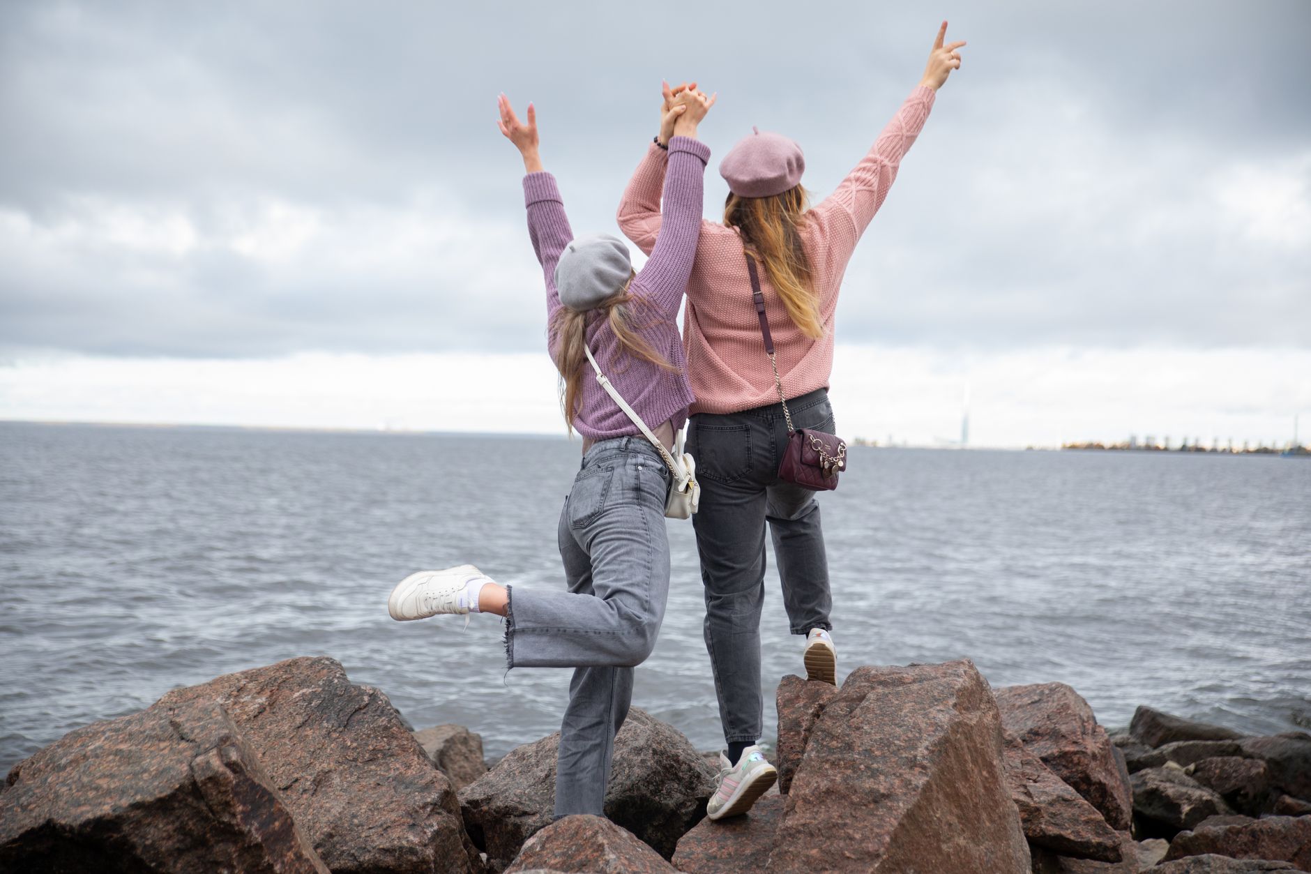 two women celebrating by the seaside rocks
